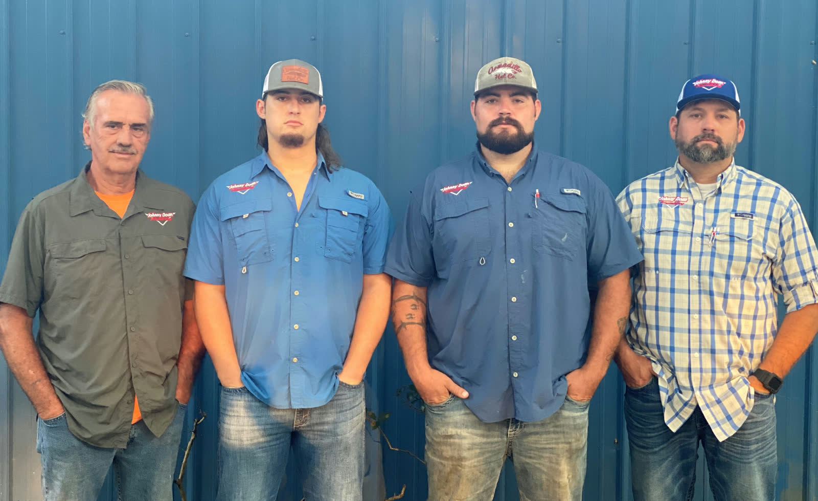Four members of the Johnny Doan Plumbing team in company shirts